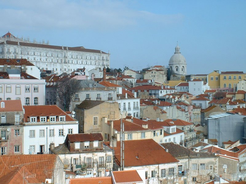 the rooftops of houses in lisbon portugal set on a hillside