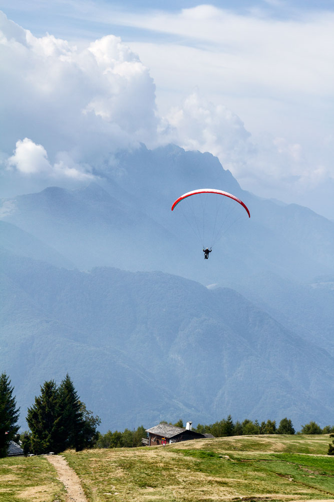 person paragliding over swiss mountain