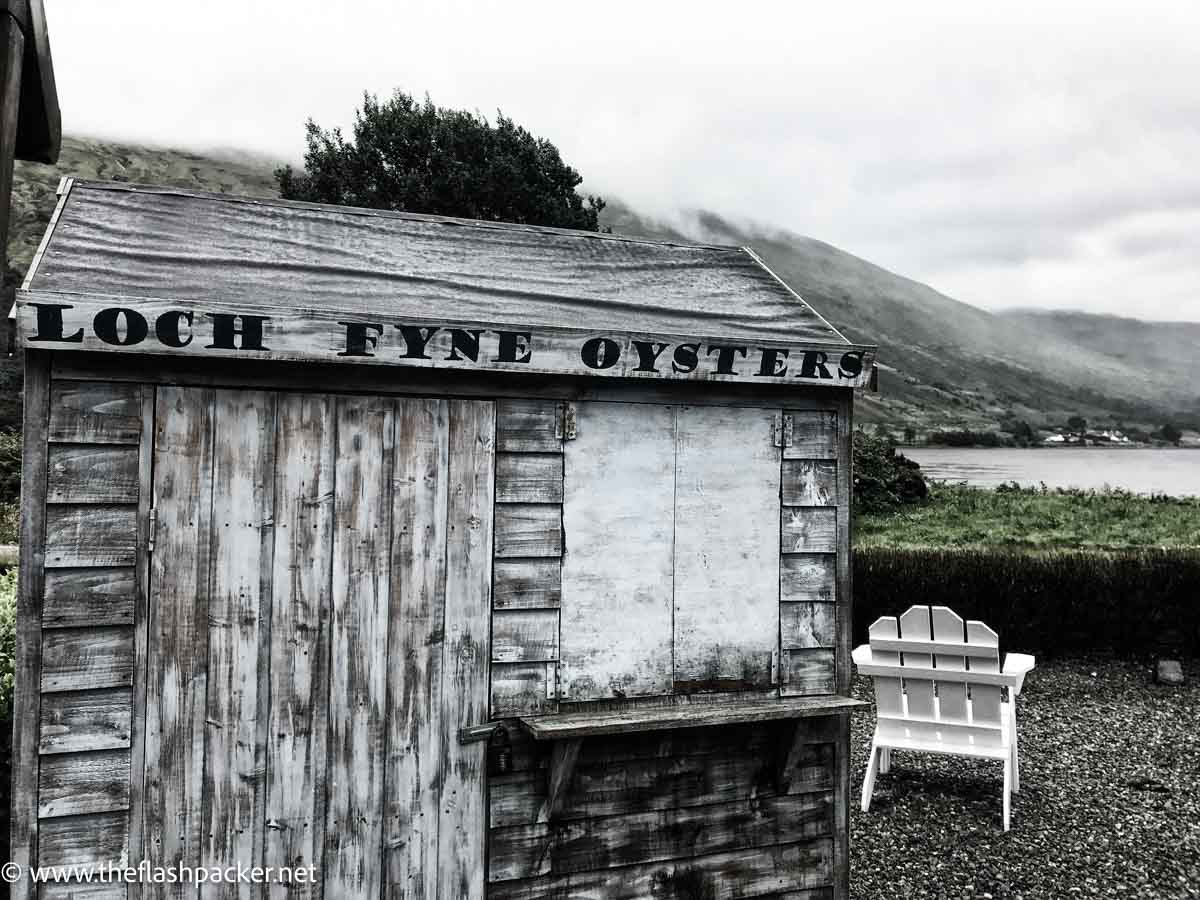 old wooden shack and chair at side of loch fyne in scotland