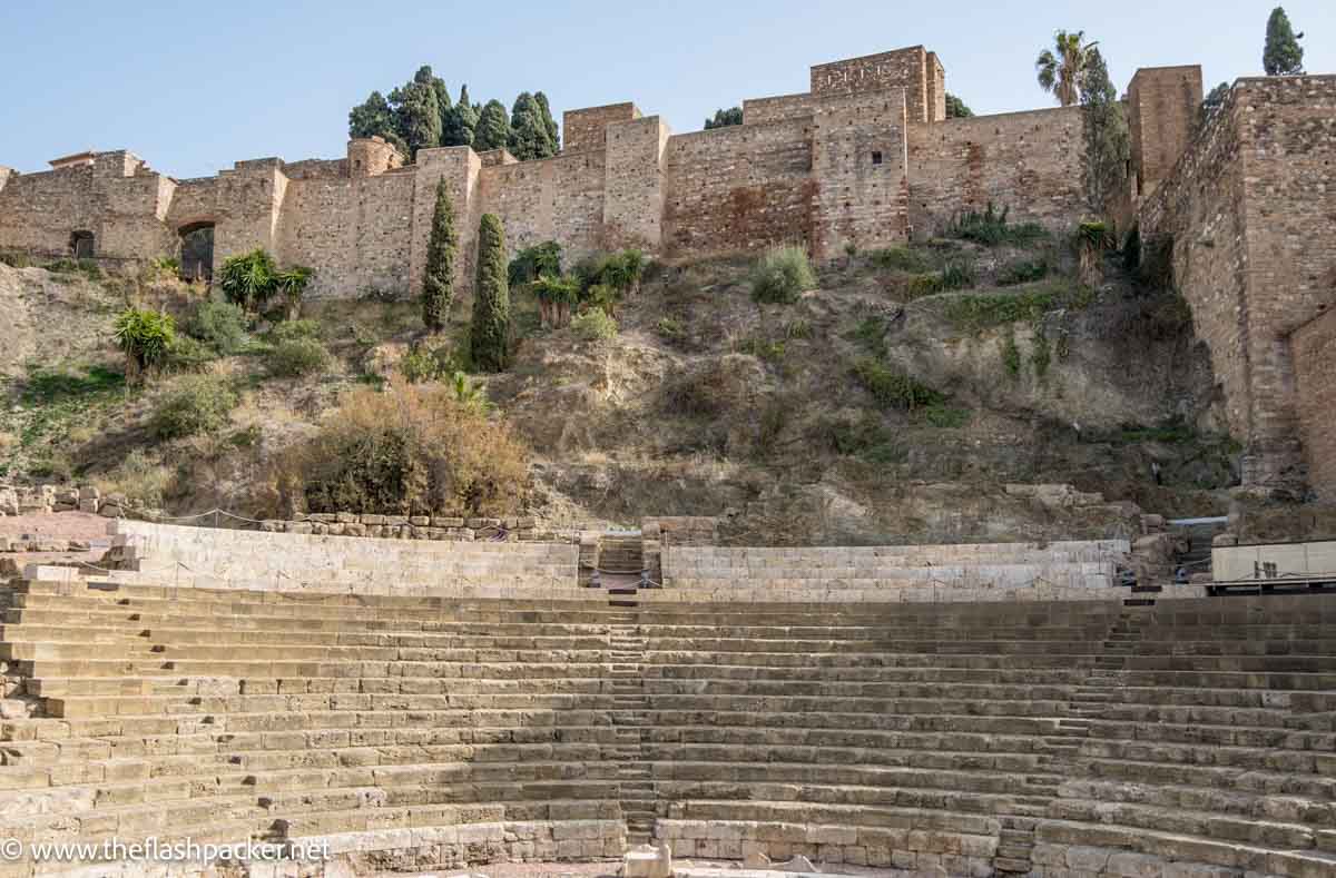 roman theatre in front of castle walls on hill