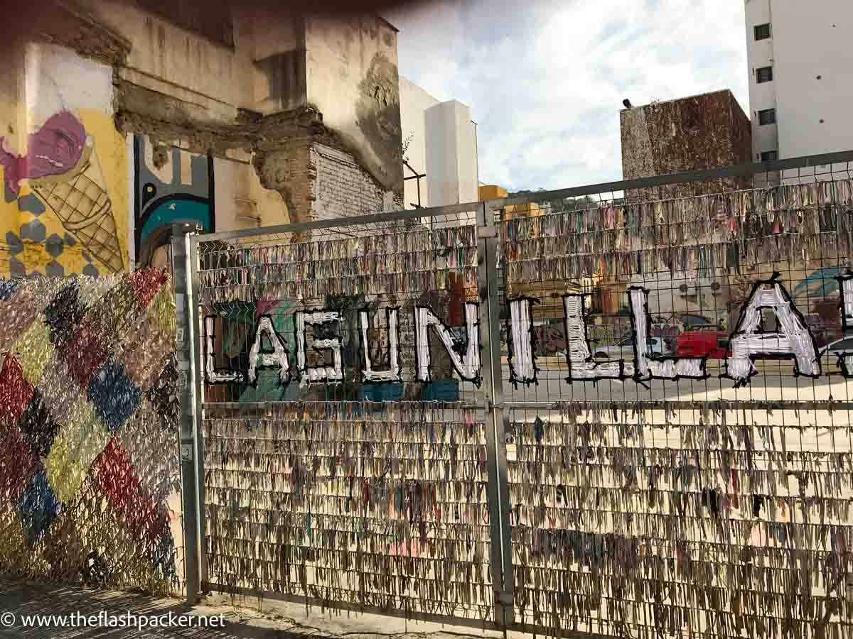 fence in front of street art in malaga spain with the ward lagunilla