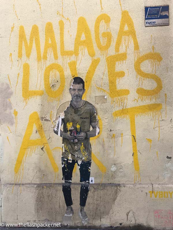 wall mural with man and dog and the words malaga loves art