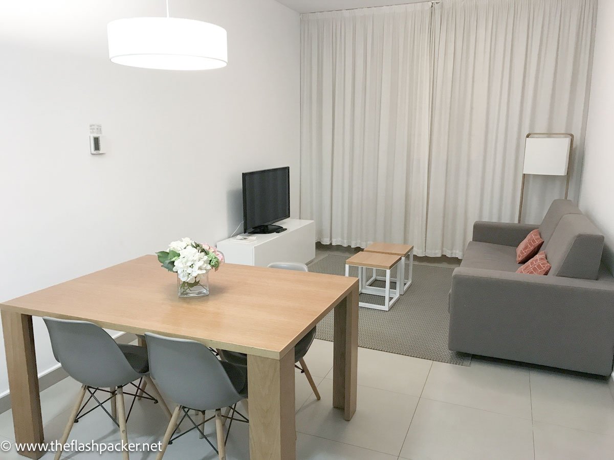 sitting room of apartment with sofa tv and table and chairs