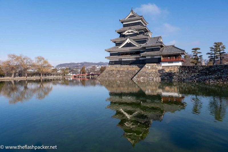 matsumoto castle reflected in the still water of moat