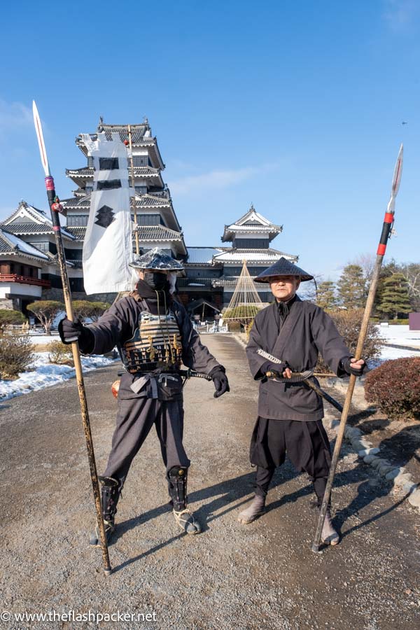 2 men posing in samurai costumes in front of matsumoto castle