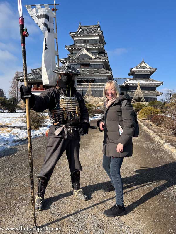 women posing next to a person dressed in samurai costume