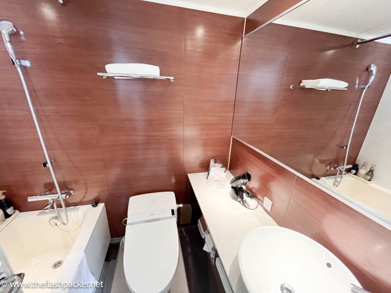 hotel bathroom with white fixtures and wooden panelling