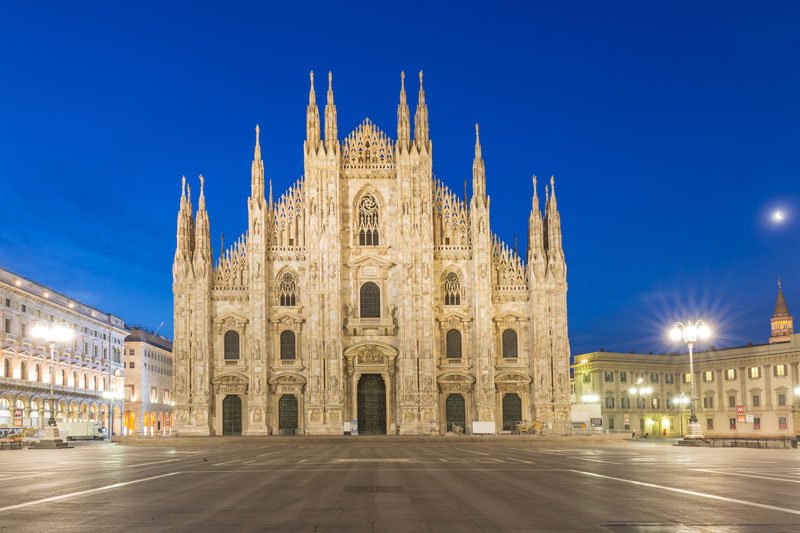 illuminated gothic facade of milan cathedral at twilight