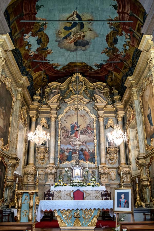 gilded altar and painted ceiling of the inside of a church in monte madeira