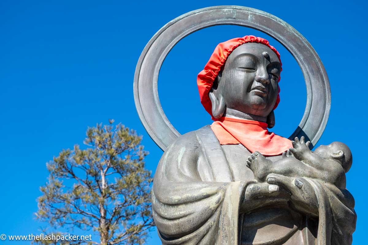 large stone sculpture of a buddhist nun holding a baby