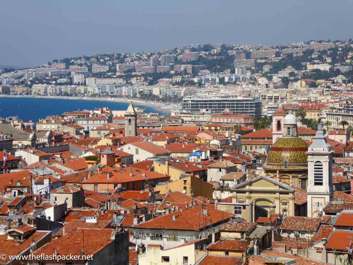 panoramic view of red rooftops and beach in nice france