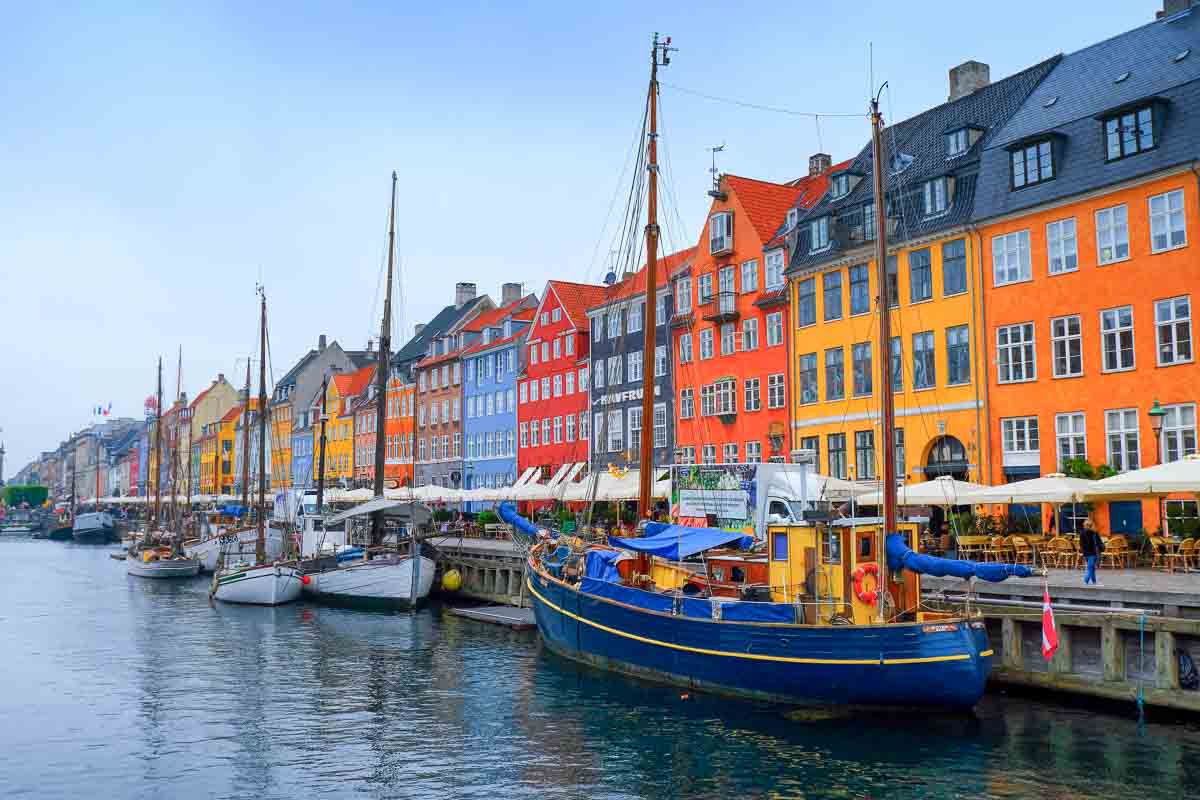 brightly coloured housesd along the waterfront with boats in nyhavn