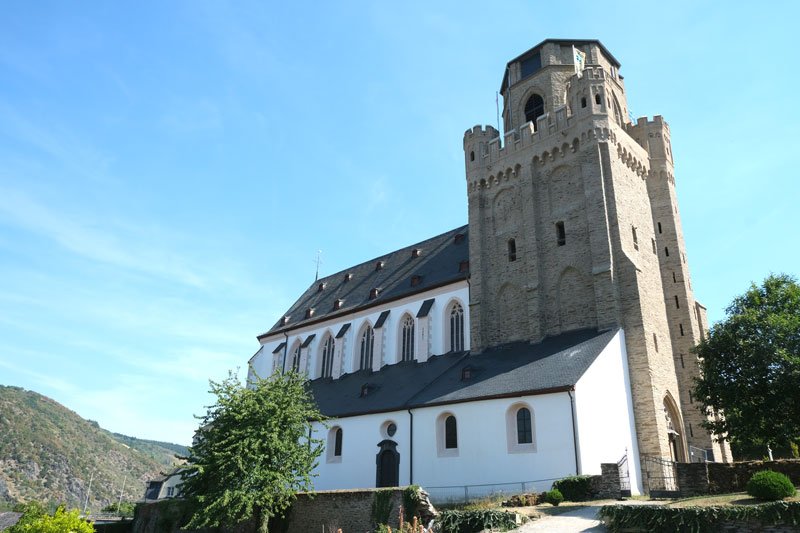 whitewashed church of st martins in oberwesel with a stone bell tower