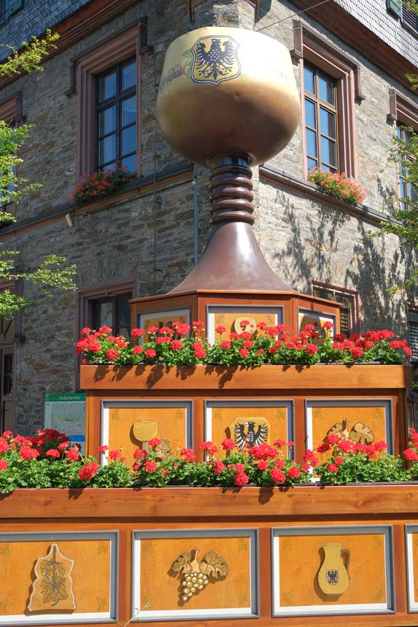 wooden tiered sculpture topped by a gian wine glass