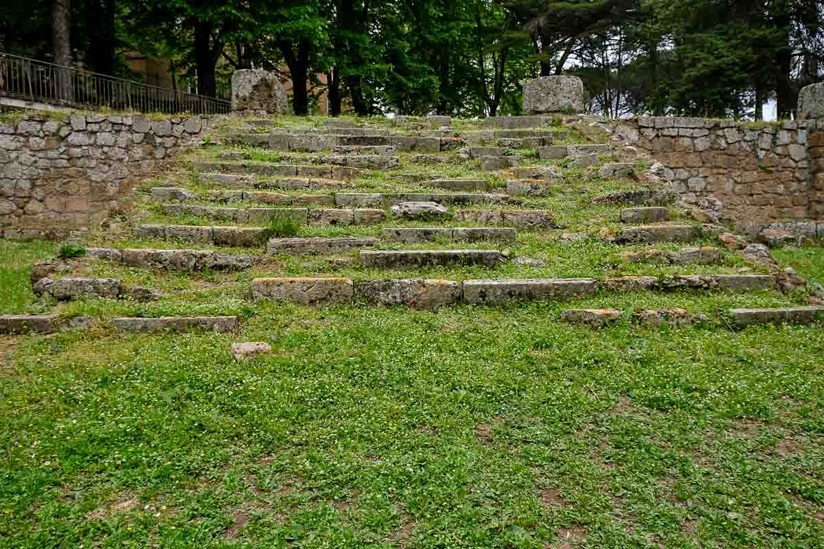 grassy area with the remains of the steps of an ancient temple