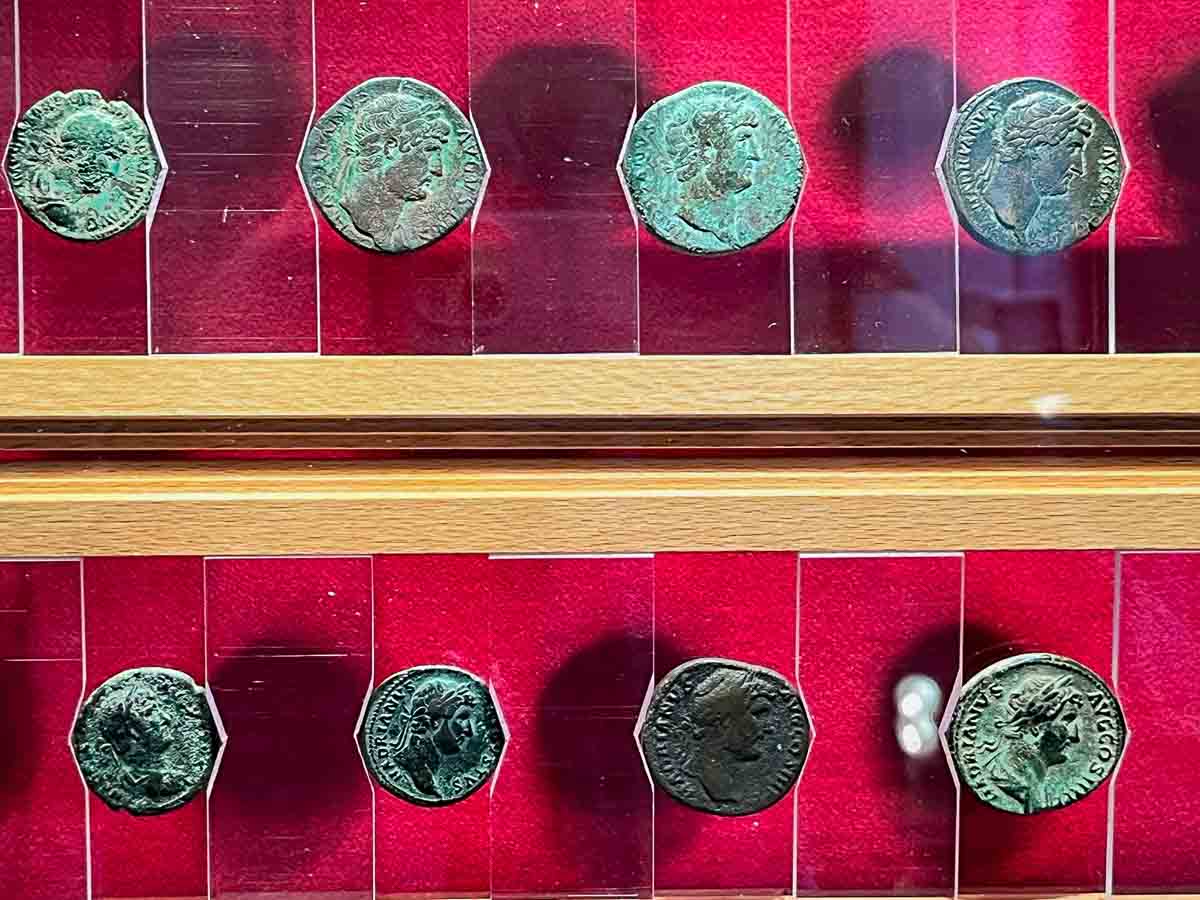 display of ancient coins against a red background