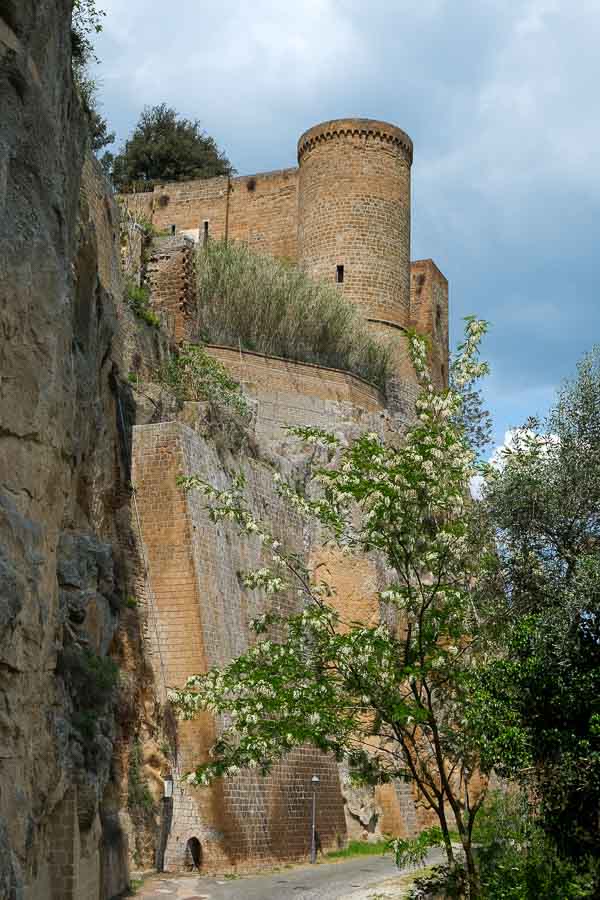 pretty pathway along the side of a city wall next to an imposing tower