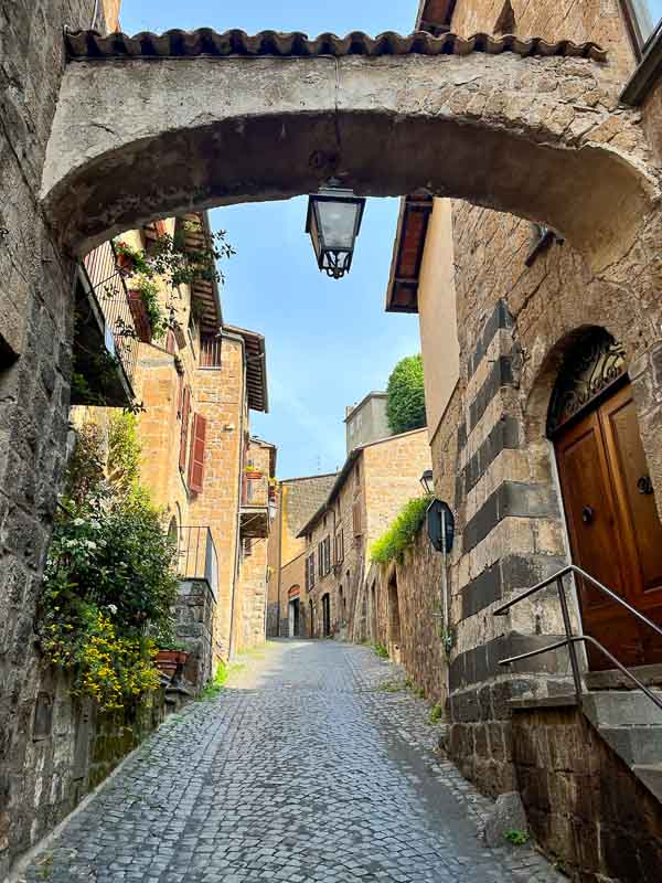 stone bridge across narrow alley in italian street