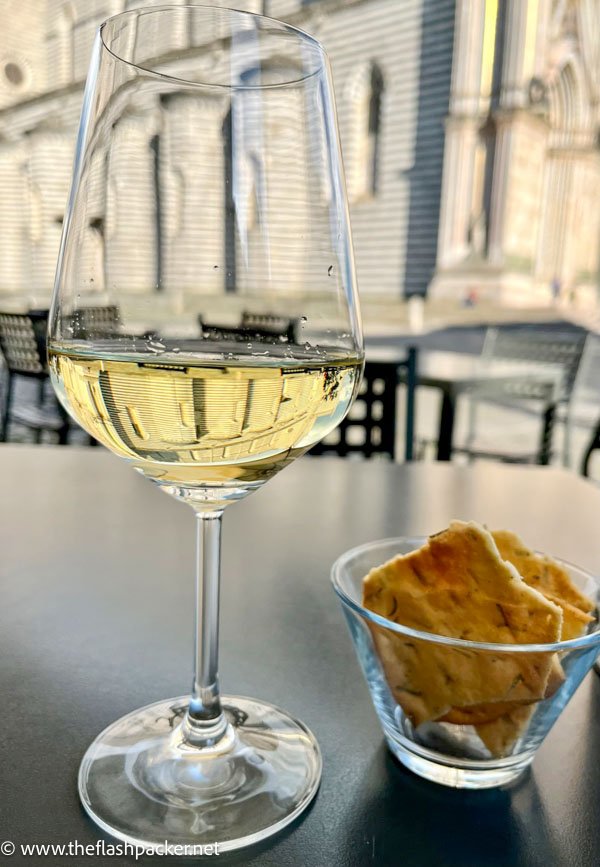 glass of white wine and a small bowl of crackers