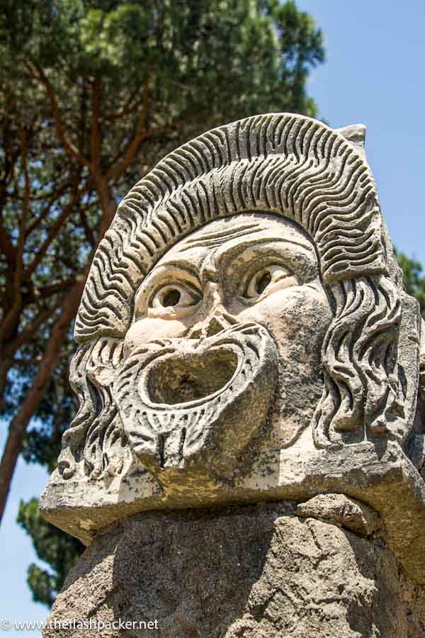 grimacing carved stone head at ostia antica