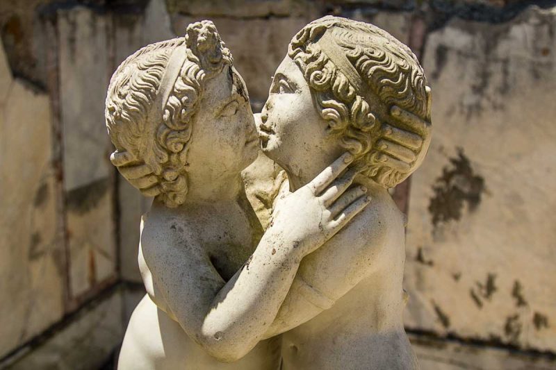 statue of two cherubs kissing at ostia antica