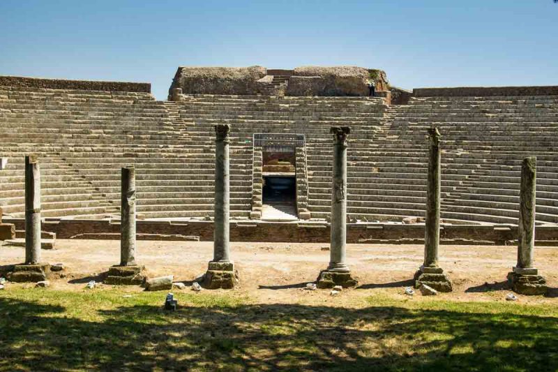 set of corinithian columns in front of roman amphitheatre