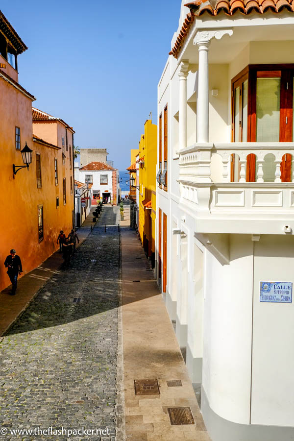 narrow street in a colonial spanish town with brightly coloured buildings