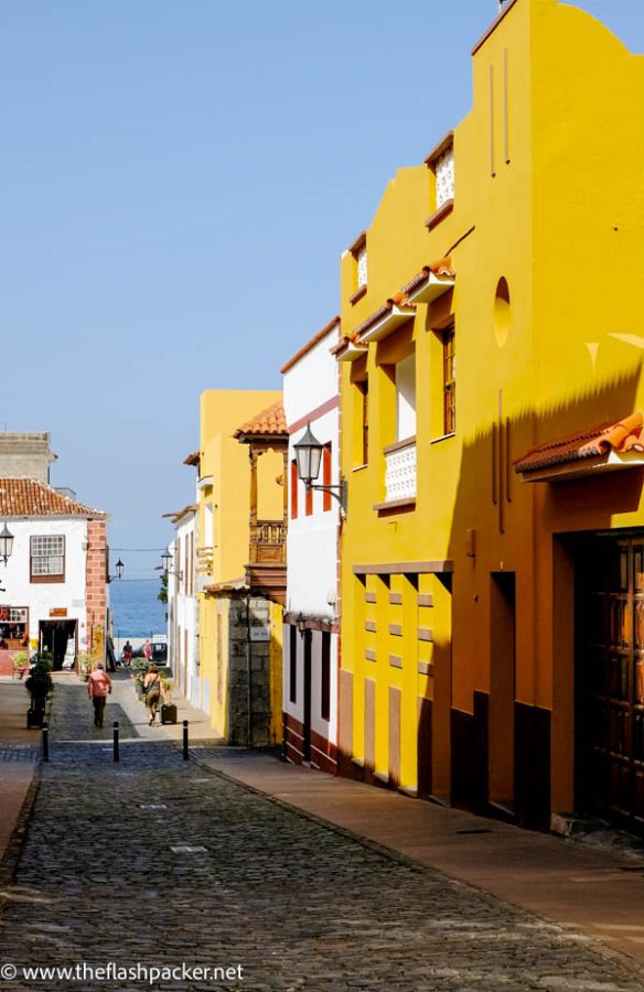 narrow street in a colonial spanish town with brightly coloured buildings