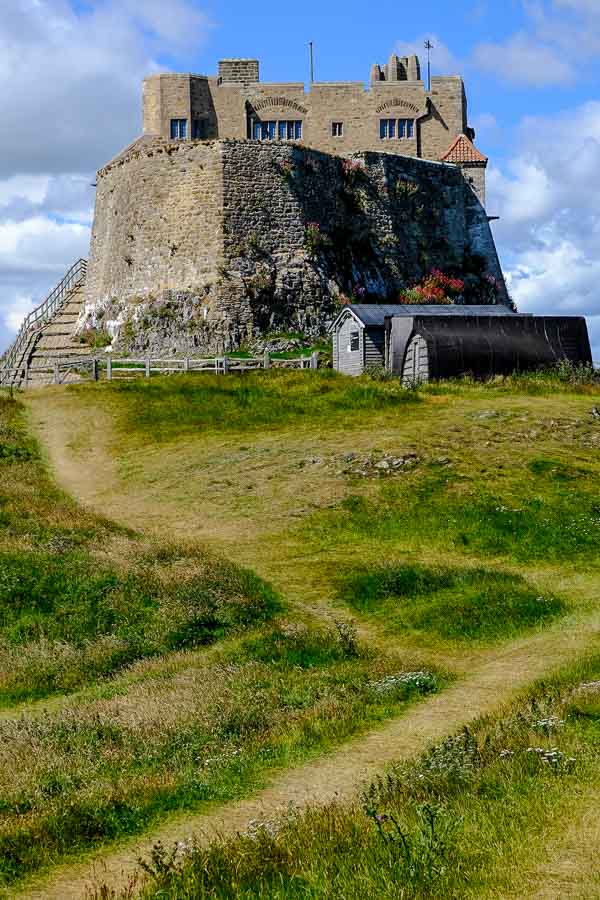 grass path leading to remains of lindisfarne castle