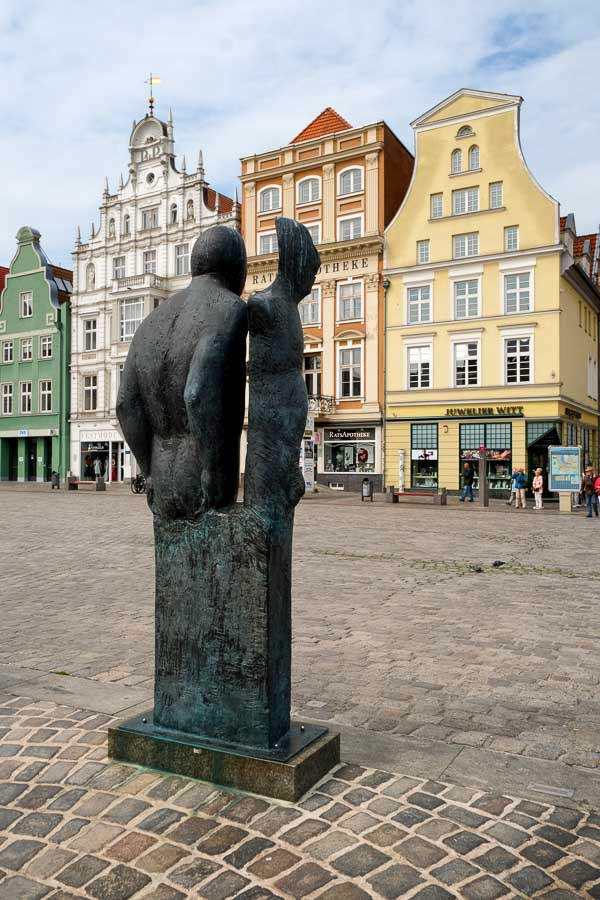 bronze statue in square in rostock with half-gabled houses