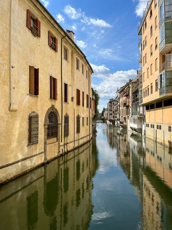 old and new buildings lining a canal in padua italy