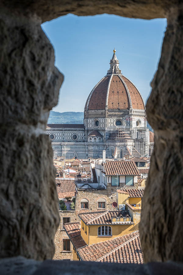 view of dome of florence cathedral framed by stone opening