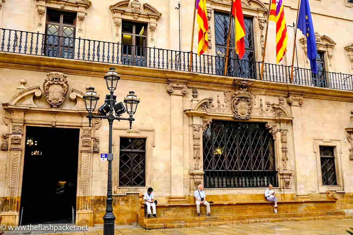 people sitting on steps of medieval building