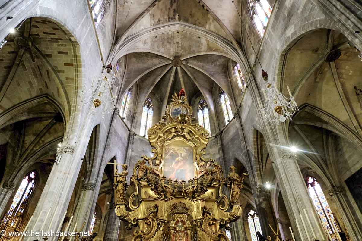 vast interior of chruch with gilded altar and vaulted ceiling