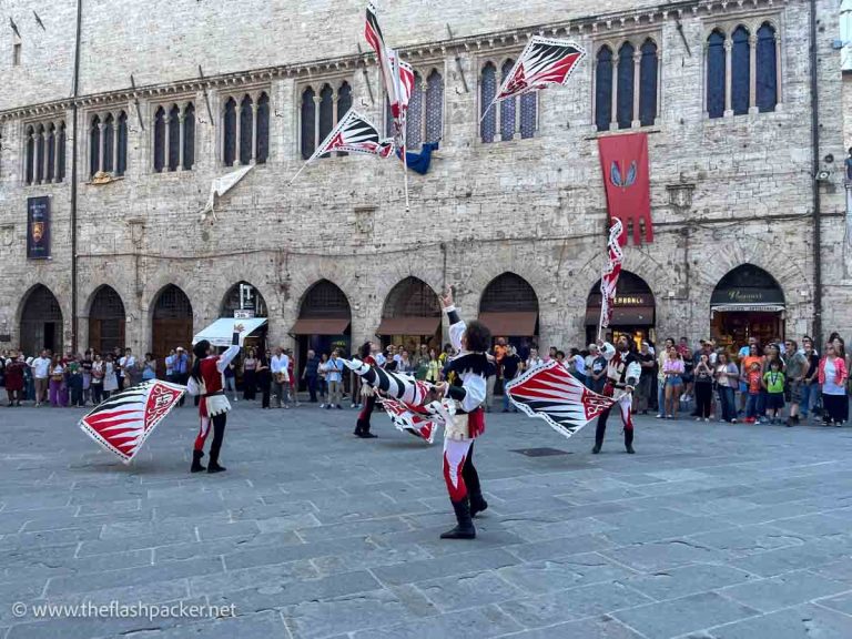 men in medieval costume throwing flags in the air