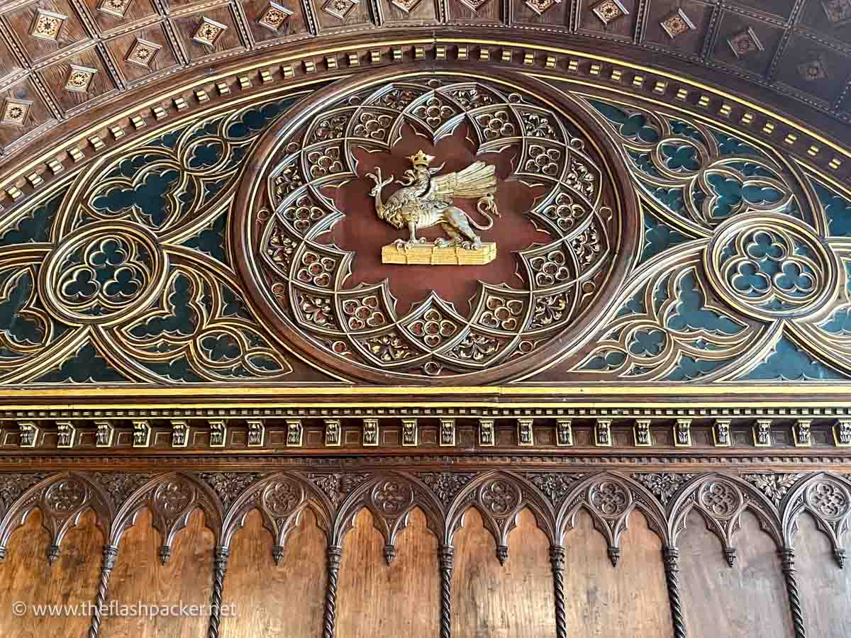 painted and gilded wooden panelling with gothic arches and heraldic insignia