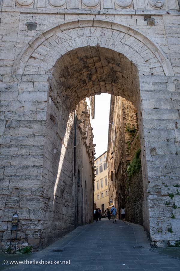 arched entrance to perugia with roman writing along top