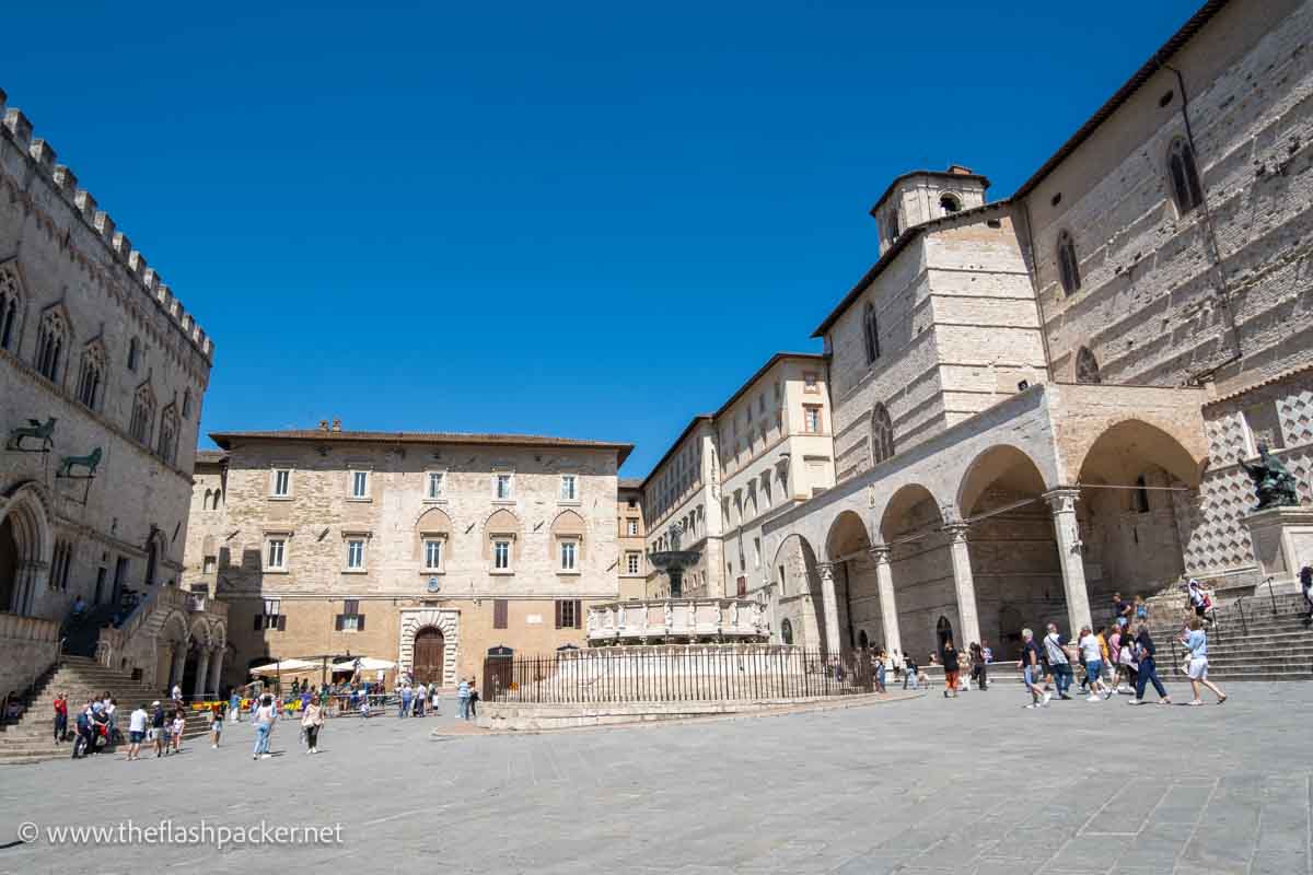 square in perugia in italy with medieval grey stone buildings and a circular fountain