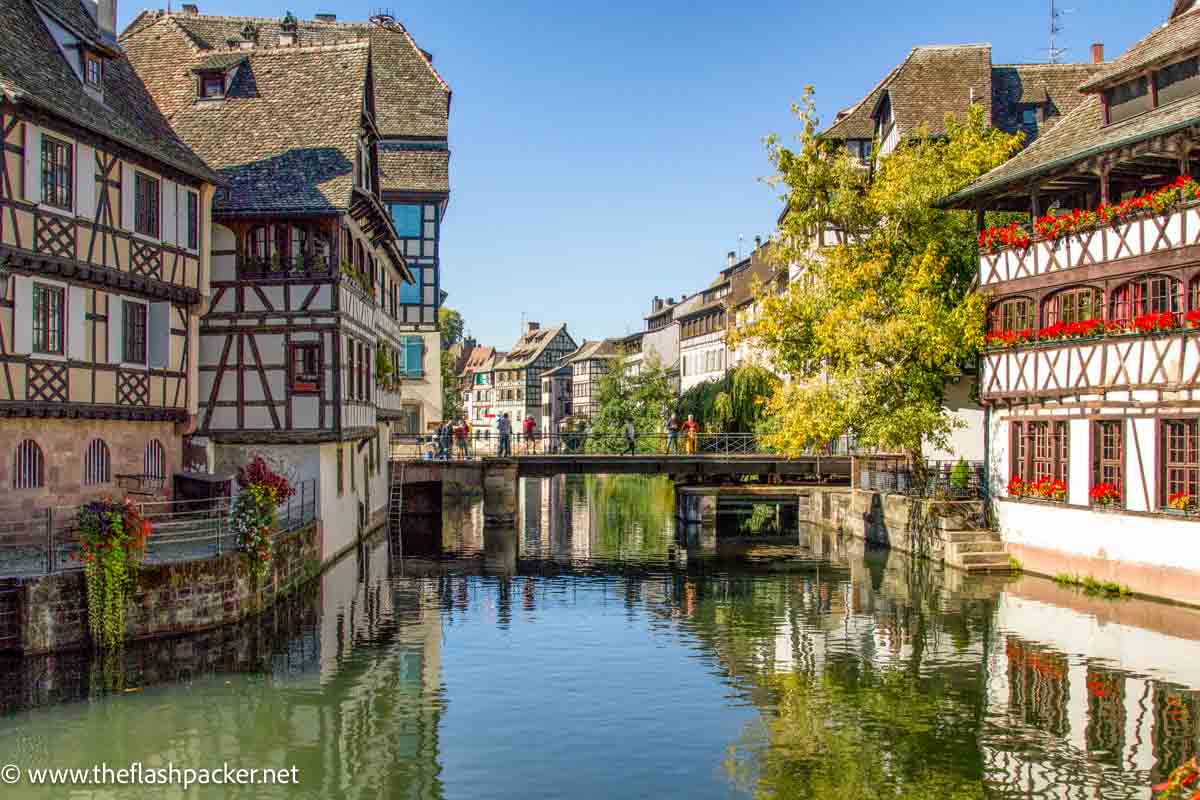 people on bridge between half timbered buildings in strasbourg france