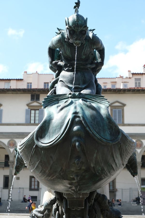 bronze statue of mythical creature spouting water from its mouth