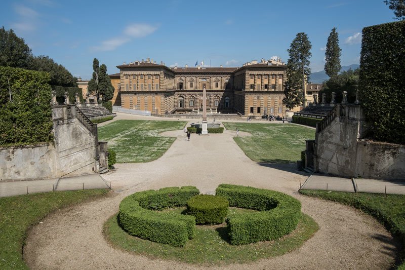 broad facade of italian palace fronted by a formal garden with a central low-cut hedge