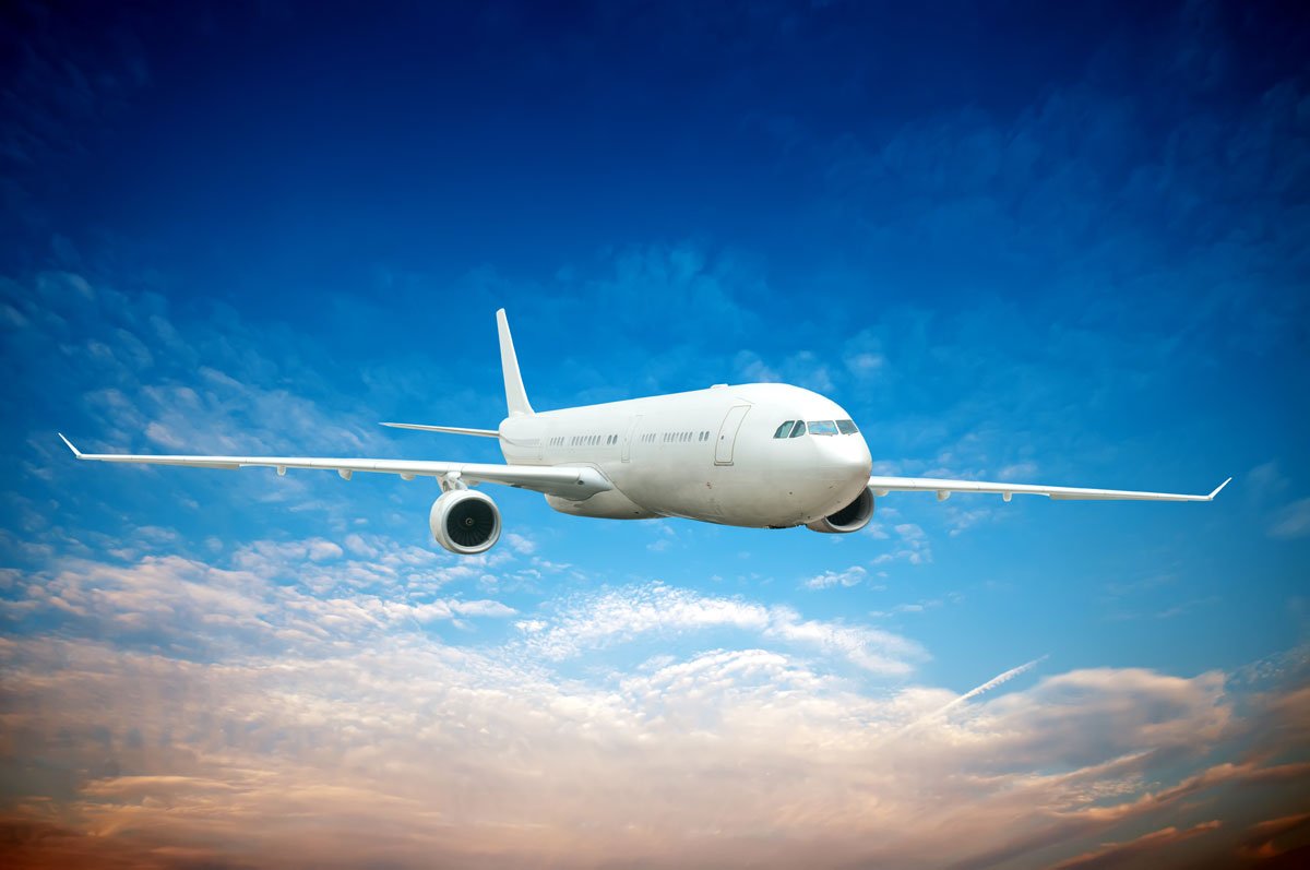 commercial aircraft flying high above clouds