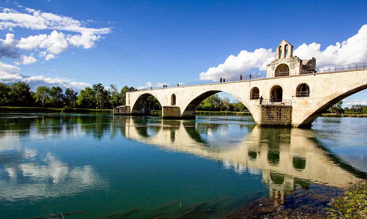 arched bridge reflected in still water in avignon-provence