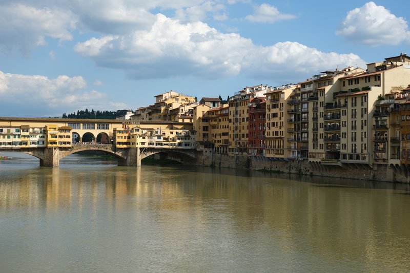 medieval houses along the side of the river arno with bridge