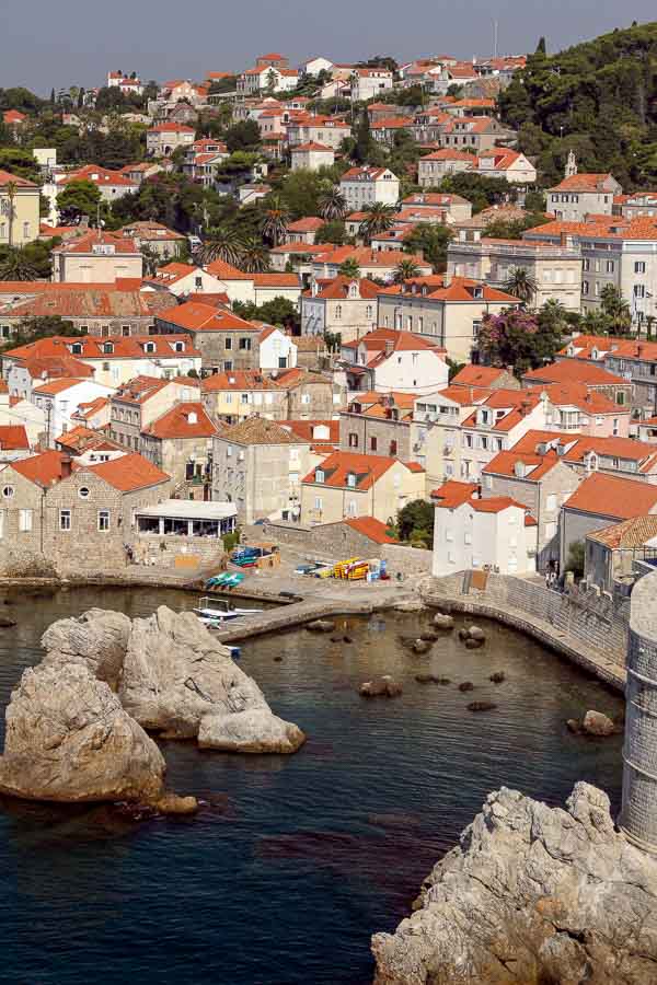 red roofed houses set on a hill rising from harbour in dubrovnik