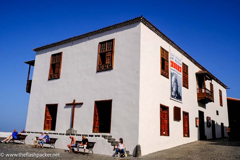 whitewashed small building and people sitting outside