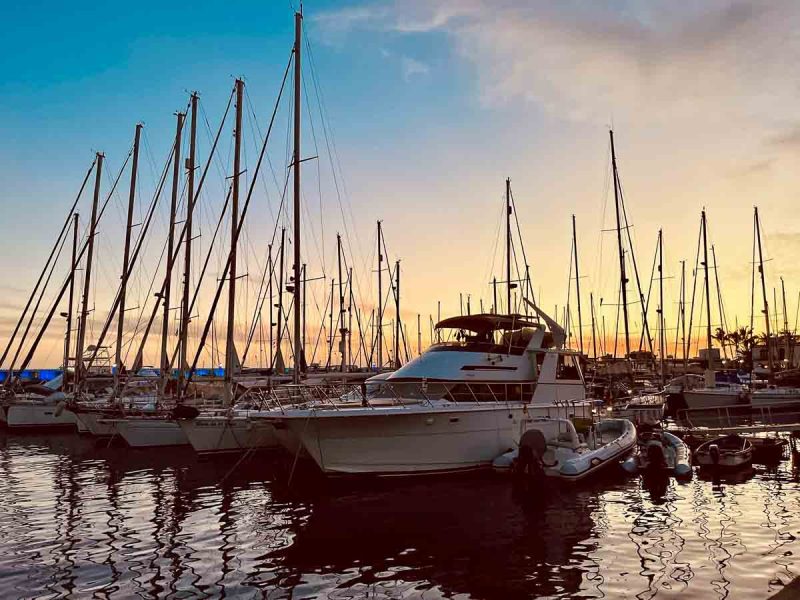 small boats lined up in marina at sunset