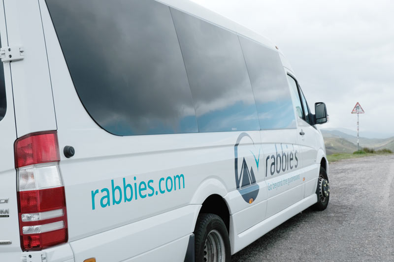 white minibus with the logo for rabbies