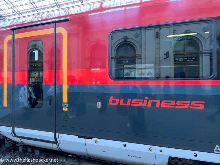 blue and red exterior of business class section of obb railjet train