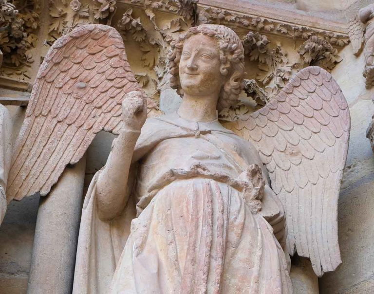 stone statue of a smiling angel at notre dame de reims cathedral